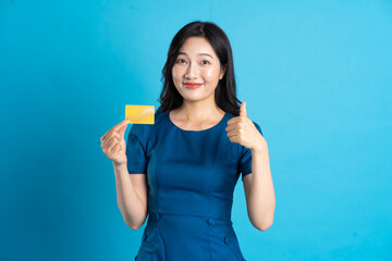 Portrait of beautiful woman in blue dress, isolated on blue background.