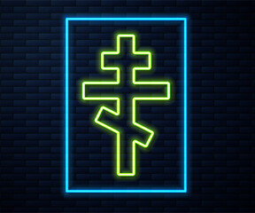 Glowing neon line Christian cross icon isolated on brick wall background. Church cross. Vector