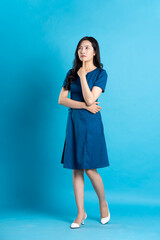 Portrait of beautiful woman in blue dress, isolated on blue background