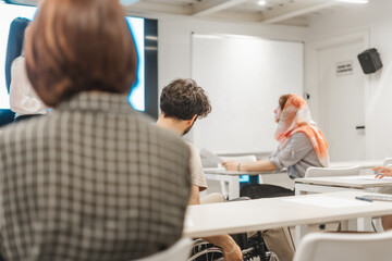 Obraz premium Multicultural coworkers at the office. Disabled male business person working with his teammates