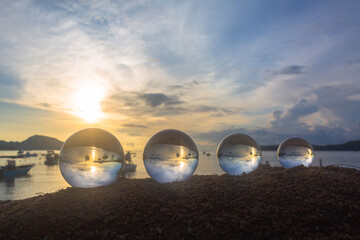 .The 4 glass balls are arranged from large to small placed on the beach at sunrise. .To see the sea...