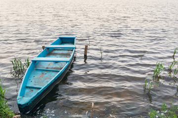 Old wooden boat on the shore of the lake. Boat for swimming. Wooden boat for fishing