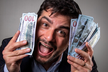Hombre festejando con muchos billetes en sus manos