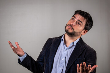 Persona mirando hacia arriba con los brazos abiertos en señal de pregunta y asistencia