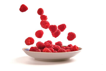 raspberries on a plate isolate on white, berries falling