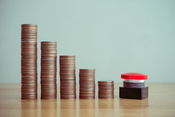 Red stop reset emergency button with stack coins as graph chart falling down background on wooden table copy space. Stop reset recession economy, global world economic crisis, inflation or FED control