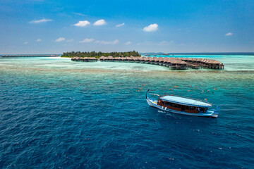Luxury island landscape in Maldives. Sail boat blue sea water horizon reef water villas. Tropical beach amazing aerial seascape view from drone. Beautiful nature people snorkel excursion, recreation 