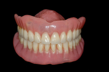 A set of full removable dentures in black background 