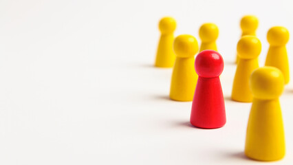 Red wooden figure standing in wood yellow team group to show influence power and empowerment....