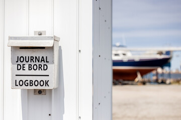 Boîte pour journal de bord de marin, avec  bateau en arrière plan, horizontal - obrazy, fototapety, plakaty