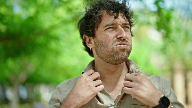 Young hispanic man sweating at park