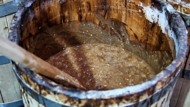 Wooden barrel with fermenting sourdough for baking bread at a craft bakery.