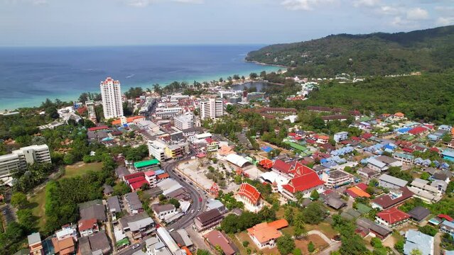 Bird's eye view of Wat Suwan Khiri Khet Temple, Karon beach, buildings, hotels. Drone aerial photography view of the road, sea and turquoise water, many houses and hotels, life on the island, nature