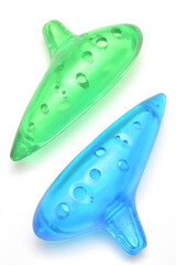 プラスチックで作られた青と緑の半透明色でカラフルな子供用のオカリナ