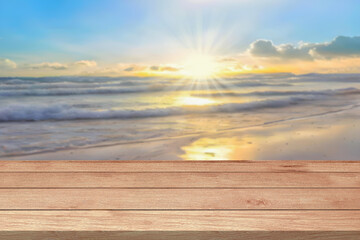 Empty wooden table top or counter and sun, sunlight blur bokeh of beach sand sea nature background. Summer holiday travel for Template mock up display montages product. Wood table plank background