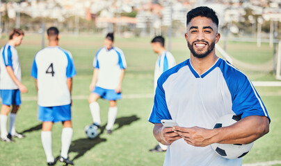 Football player, phone and portrait at game on a field for sports and fitness app. Happy male soccer or athlete person outdoor for challenge, competition or motivation with online communication © Daniels C/peopleimages.com