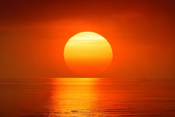 Obraz na płótnie Canvas 海に沈む真っ赤に染まる夕方の大きな夕日