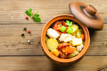 Pork vegetables stew in a pot on wooden background. Top view, flat lay, copy space.