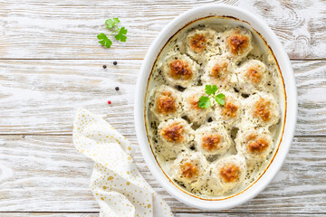 Oven baked garlic  parmesan spinach meatballs in baking dish. Top view, copy space, flat lay.