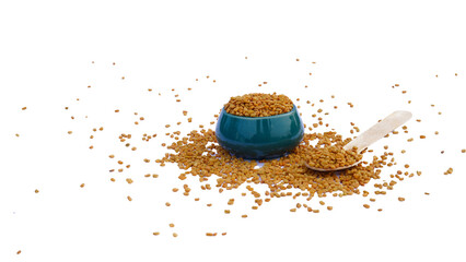 fenugreek seeds in wooden bowl and spoon isolated on white background. Spices and food ingredients.