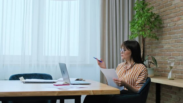 Middle aged business woman at workplace using laptop for virtual video meeting