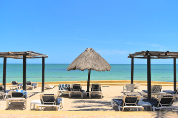Chairs and parasol on a sand beach and horizon (Merida, Yucatan, Mexico) - obrazy, fototapety, plakaty