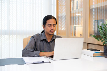 Asian businessman typing on laptop during work at home office. Freelance working online