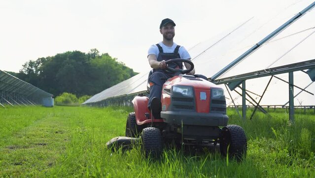Staff in the solar photovoltaic panels with mowers cut weeds