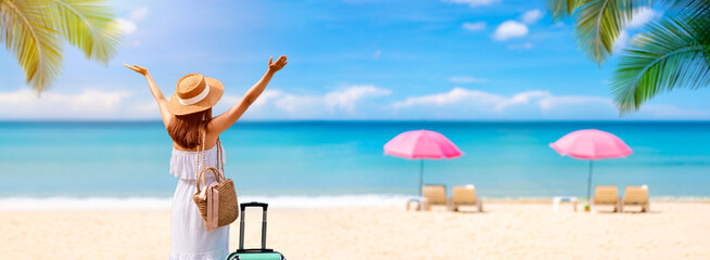Young woman tourist enjoying the tropical beautiful white sand beach with sun bed background,...