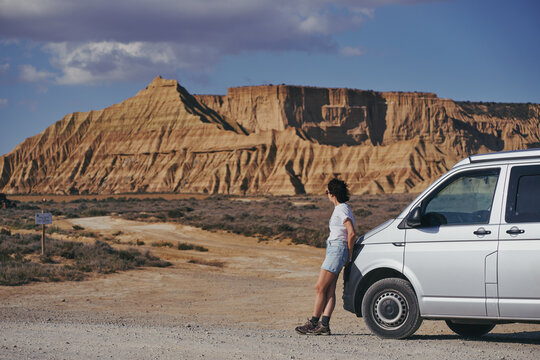 Femme brune accoudée à un van dans le desert des Bardenas Reales