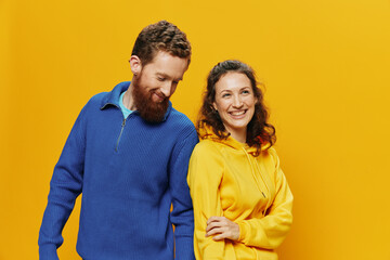 Man and woman couple smiling cheerfully and crooked with glasses, on yellow background, symbols...
