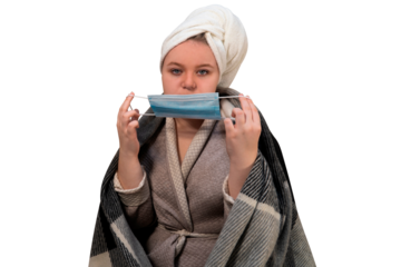 A girl with symptoms of a cold puts on a protective medical mask on her face on a transparent background. The concept of medicine, healthcare, hygiene and home treatment