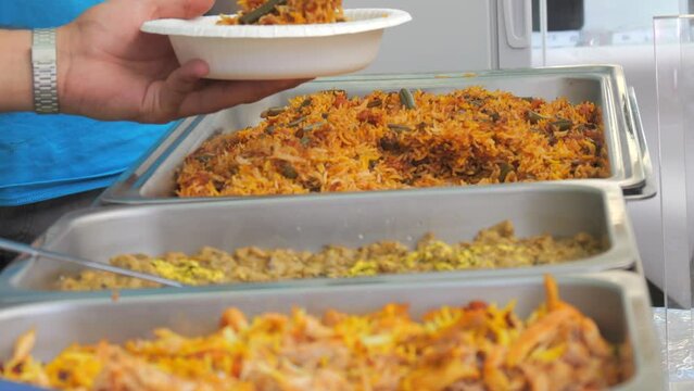 Huge dishes with rice or pilaf on the counter of the street food festival