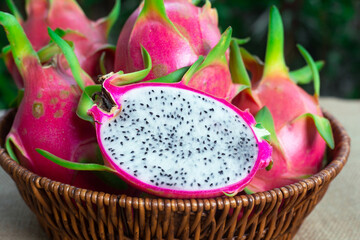 Dragon fruit, Pitaya or Pitahaya cut in half in a wicker basket, close-up, healthy fruit