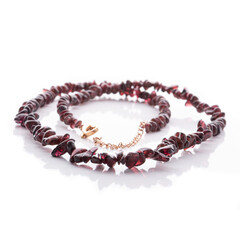 Dark red garnet natural stone necklace on white background. Energy crystals. Healing gemstones....