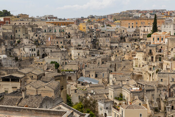 Fototapeta na wymiar View of the city of Matera by day. Typical Salento illuminations during the holidays. Feast of the Brown Madonna, Matera. Prehistoric caves from the Murgia.Mysterious and ancient land among the stones