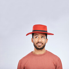 Fashion, hat and mockup with a confused man in studio isolated on a gray background in doubt about his style. Question, mistake and frown with a young asian male model in trendy red headwear