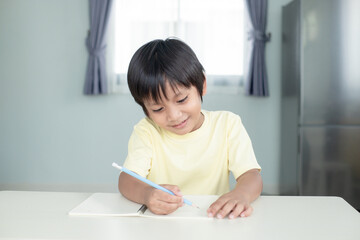 Naklejka premium Happy boy kid earning and writing with smiling face