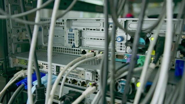 close-up of a pile of network patch cables sorted in a rack cabinet leading from a patch panel in a server rack in a data center room