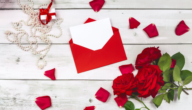 Bouquet of flowers roses of the valley and letter on wooden table from above, top view, flat lay
