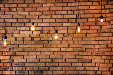 Old electric incandescent lamps with tungsten filament. Against the backdrop of a brick wall....