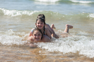 fun siblings on a day at the beach. they play as a family at the seashore.