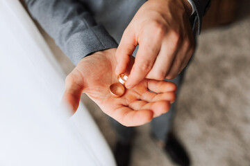 two gold wedding rings on a man's hand in natural light