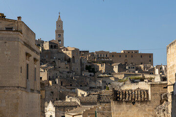 Obraz premium View of the city of Matera by day. Typical Salento illuminations during the holidays. Feast of the Brown Madonna, Matera. Prehistoric caves from the Murgia.Mysterious and ancient land among the stones