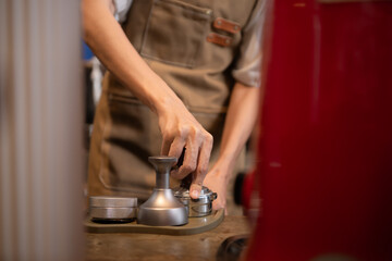 Close-up of barista hands using Portafilter for making espresso.