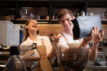 The barista fills the coffee grinder with roasted coffee beans. to prepare coffee for customers