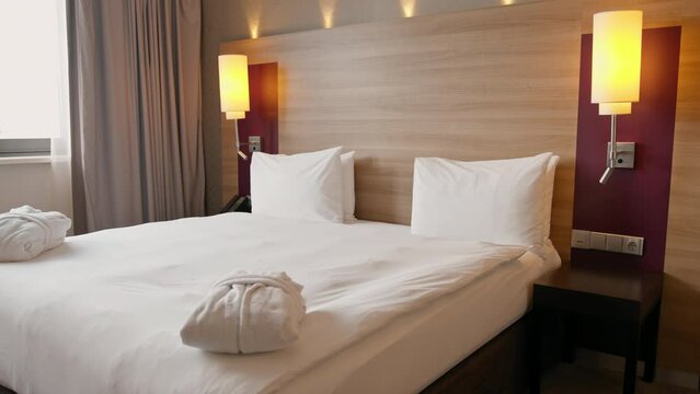 the interior of a luxury hotel room after cleaning white robes folded on the bed concept of cleanliness and hospitality