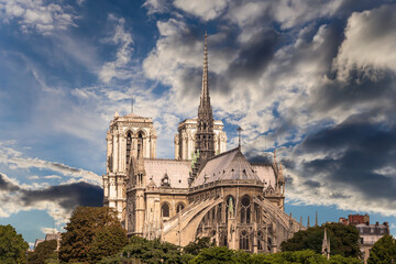 Fototapeta na wymiar Notre Dame de Paris (against the background of sky with clouds), also known as Notre Dame Cathedral or simply Notre Dame, is a Gothic, Roman Catholic cathedral of Paris, France