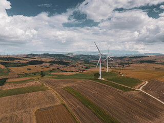 aerial view of a wind farm in Campania Italy. The wind turbines are immersed in cultivated agricultural fields