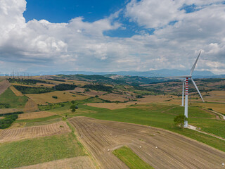 aerial view of a wind farm in Campania Italy. The wind turbines are immersed in cultivated agricultural fields